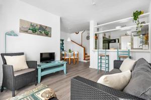 a living room with a couch and chairs and a tv at Apartamento Udane Menorca by Mauter Villas in Cala en Blanes
