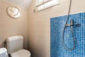 a bathroom with a toilet and a shower with blue tiles at Apartamento Udane Menorca by Mauter Villas in Cala en Blanes +14 photos