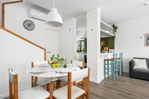 a white dining room with a white table and chairs at Apartamento Udane Menorca by Mauter Villas in Cala en Blanes