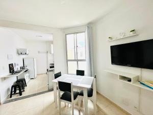 une salle à manger blanche avec une table et une télévision dans l'établissement AZUL DO MAR - Rio das Ostras, à Rio das Ostras