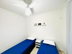 une chambre avec deux lits et un ventilateur de plafond dans l'établissement AZUL DO MAR - Rio das Ostras, à Rio das Ostras 22 autres photos