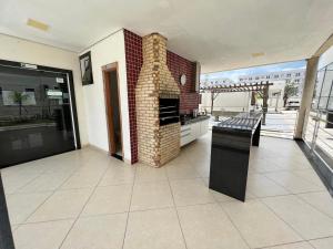 une cuisine avec une cheminée en briques sur une terrasse dans l'établissement AZUL DO MAR - Rio das Ostras, à Rio das Ostras