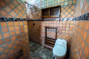 a tiled bathroom with a toilet and a window at Hotel Le Chateau Guatape in Guatapé