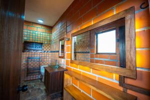 ein Badezimmer mit orangefarbenen gefliesten Wänden und einem Fenster in der Unterkunft Hotel Le Chateau Guatape in Guatapé