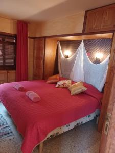 a bedroom with a large bed with a red comforter at Willkommen im Paradies - Welcome in Paradise - Bienvenidos al paraíso in La Matanza de Acentejo