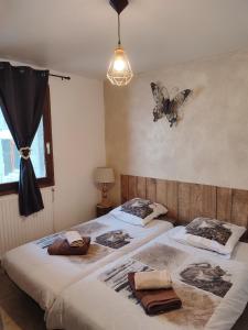 2 letti in una camera da letto con una farfalla sul muro di Õ 2040 Chambre Mélèze a Saint-Véran