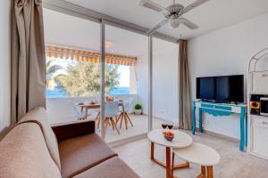 ein Wohnzimmer mit einem Sofa und einem Tisch in der Unterkunft Sueño Azul FRONT MER in Callao Salvaje