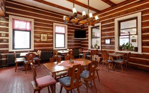 a restaurant with wooden walls and tables and chairs at Apartmán Konírna in Harrachov