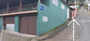 um edifício com duas portas de garagem ao lado de uma rua em chalé do Radiola em Ilhabela