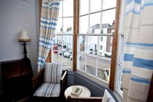 a living room with a chair and a window at Blue Skies in Deal