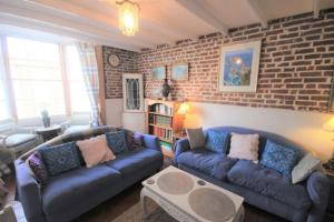 a living room with two couches and a brick wall at Blue Skies in Deal