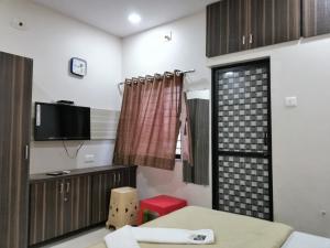 Habitación con cama, TV y ventana. en Hotel Shiv Regency en Kukma