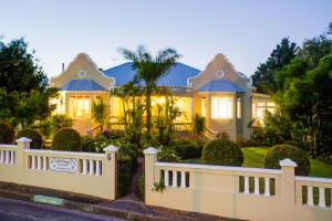 una casa con una cerca blanca delante de ella en 6 on Kloof Guest House, en Bredasdorp