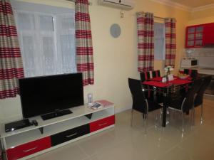 a living room with a dining table and a television at Apsara Villas in Flic-en-Flac