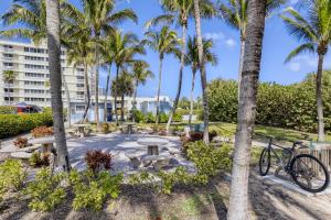 una bicicleta estacionada junto a un parque con palmeras en Singer Island Stunner 2 BR, en West Palm Beach