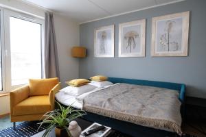 - une chambre avec un lit et une chaise dans l'établissement Tallinn City Apartments Roosikrantsi, à Tallinn