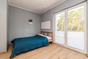 een slaapkamer met een bed en een groot raam bij WILLA MORSKA Beach Apartment in Sztutowo