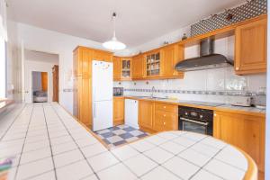 a kitchen with wooden cabinets and a white tiled floor at Nice 3 Bedroom Villa in El Duque in Adeje