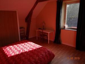 a bedroom with a red bed and a desk and a window at Ferme rénovée avec verger, 7 km du Mans, cheminée, 4 chambres, draps inclus, calme assuré - FR-1-410-251 in La Bazoge