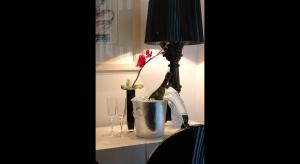 a table with a lamp and a vase with a flower in it at Andromeda Boutique Hotel in Kastoria
