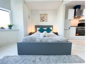 um quarto com uma cama grande e almofadas azuis em 1Bd Glasgow Apartment em Glasgow