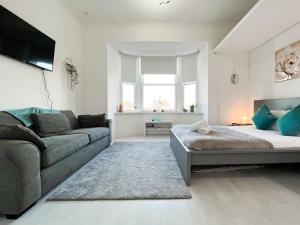 格拉斯哥的住宿－1Bd Glasgow Apartment，客厅配有床和沙发