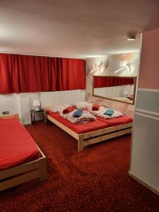 ein Schlafzimmer mit 2 Betten und einem roten Vorhang in der Unterkunft City-Apartments Hamburg in Hamburg