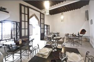 - un restaurant avec des tables et des chaises dans une salle dans l'établissement Riad El Maâti, à Rabat