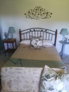 高登灣的住宿－Crossroads Guestrooms，一间卧室配有一张大床、两张桌子和两盏灯。