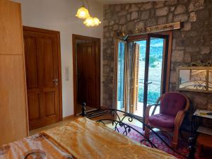 - une chambre avec un lit, une chaise et une fenêtre dans l'établissement Xenios Petritis, à Lébadée
