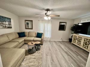 a living room with a couch and a flat screen tv at Spacious House Minutes to Beach, Casino, Aquarium in Long Beach