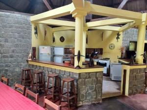 een keuken met een bar met krukken eromheen bij VILLA LA RUCHE - Iles aux nattes in Ile aux Nattes