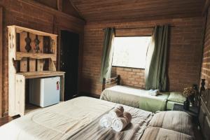 1 Schlafzimmer mit 2 Betten und einem Fenster in einem Gebäude in der Unterkunft Chalés Vida Verde in Bom Jardim de Minas