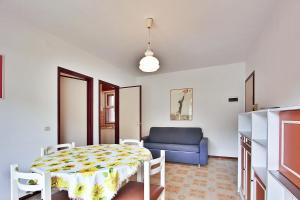 un soggiorno con tavolo e divano blu di Residenza Cedri a Lignano Sabbiadoro
