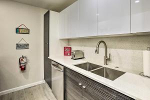 a kitchen with white cabinets and a sink at Fort Lauderdale Condo with Patio, Near Canal! in Fort Lauderdale