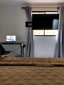 Moderna Cabaña con tinaja caliente في بيركو: غرفة نوم بسرير ومكتب ونافذة