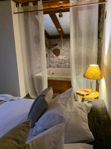 1 dormitorio con 1 cama con cortinas y lámpara en Café com Morada - Cama e Café, en Jundiaí