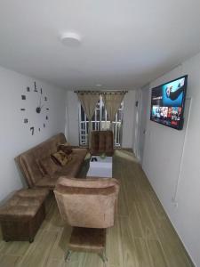a living room with a couch and a tv at Hermosa casa ideal para el descanso in Rionegro