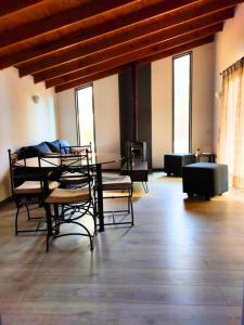 Moderna Cabaña con tinaja caliente في بيركو: غرفة بها كراسي وطاولة وبعض النوافذ