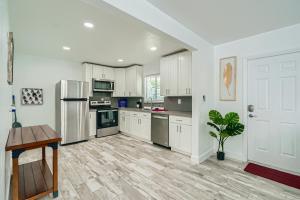 a kitchen with white cabinets and a wooden floor at Singer Island Stunner 2 BR in West Palm Beach