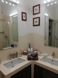a bathroom with two sinks and a large mirror at Antico Casale Il Borgo San Martino in Campo in San Martino in Campo