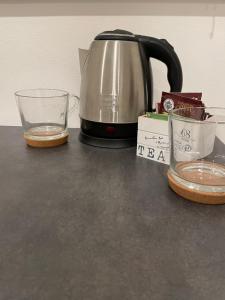 パルマにあるLuxury 2 al duomo di parmaのカウンターの上にティーケトルとコップ一杯の水