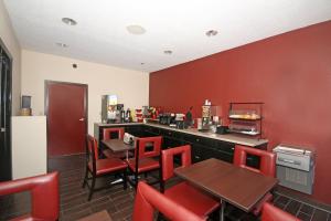 ein Restaurant mit roten Wänden, Tischen und Stühlen in der Unterkunft Red Roof Inn Gaffney in Gaffney