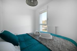 1 dormitorio con cama verde y ventana en La Maison Des Lys YourHostHelper en Gujan-Mestras