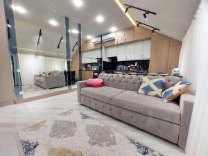 a living room with a couch and a kitchen at Supper Apartment in Tashkent