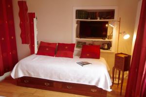 1 dormitorio con 1 cama con almohadas rojas en L ESCALE EN BEAUCE, en Maisons