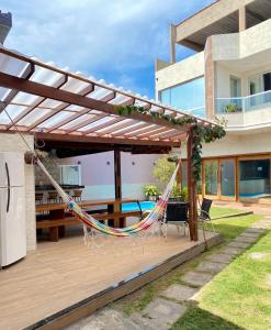- un hamac sur une terrasse en face d'une maison dans l'établissement Casa temporada com piscina, à Vila Velha