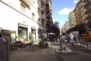 un hombre caminando por una calle de la ciudad con una floristería en Enea Holiday House, en Roma