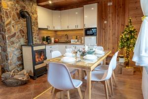 a kitchen and dining room with a table and a fireplace at Pocztówka Z Mizernej, Drewniane domki z widokiem na Tatry, Kominek, Pieniny, 1 km od Jeziora Czorsztyńskiego i Velo Czorsztyn in Kluszkowce
