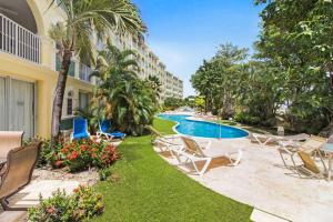 a resort yard with chairs and a swimming pool at Sapphire Beach Condos in Christ Church